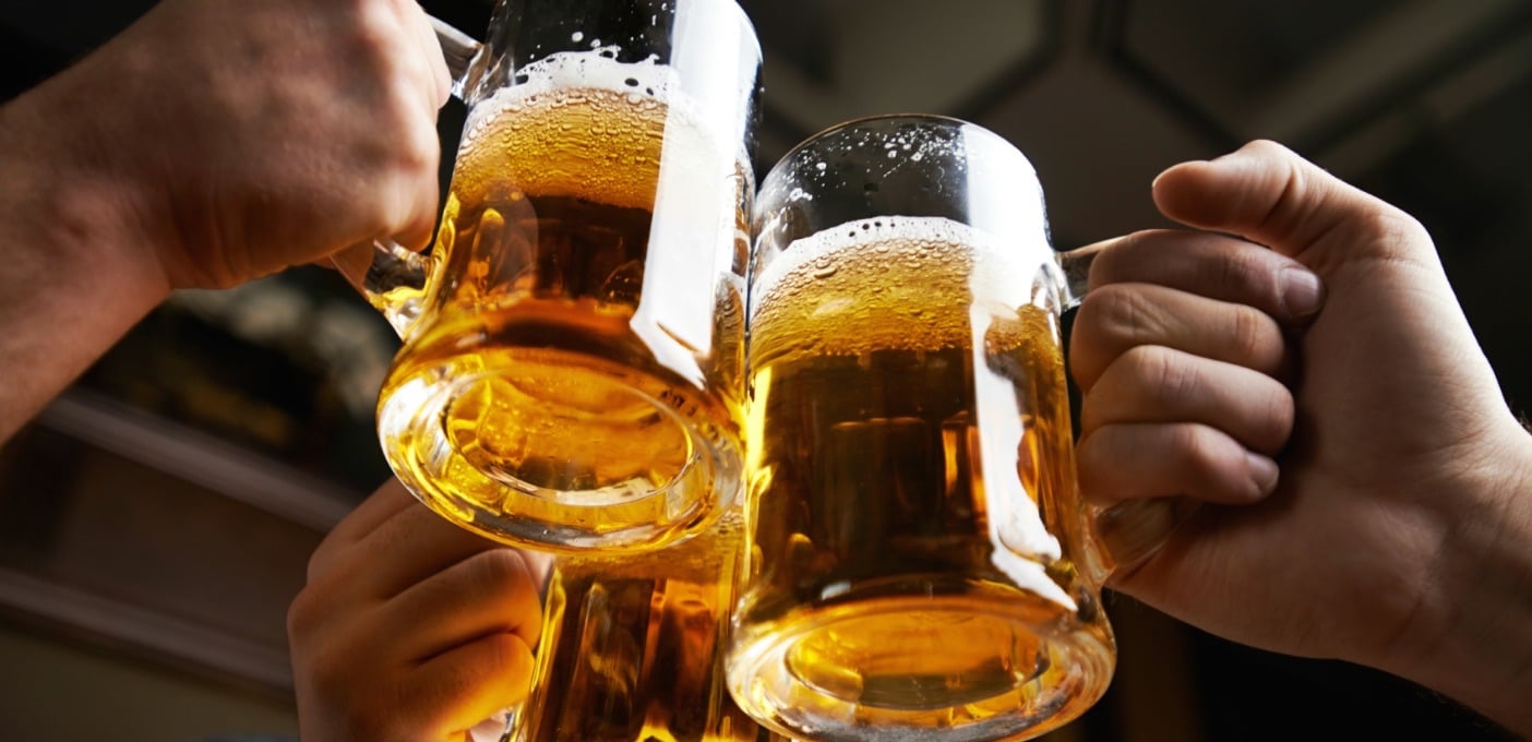 Hands of three men toasting with beer